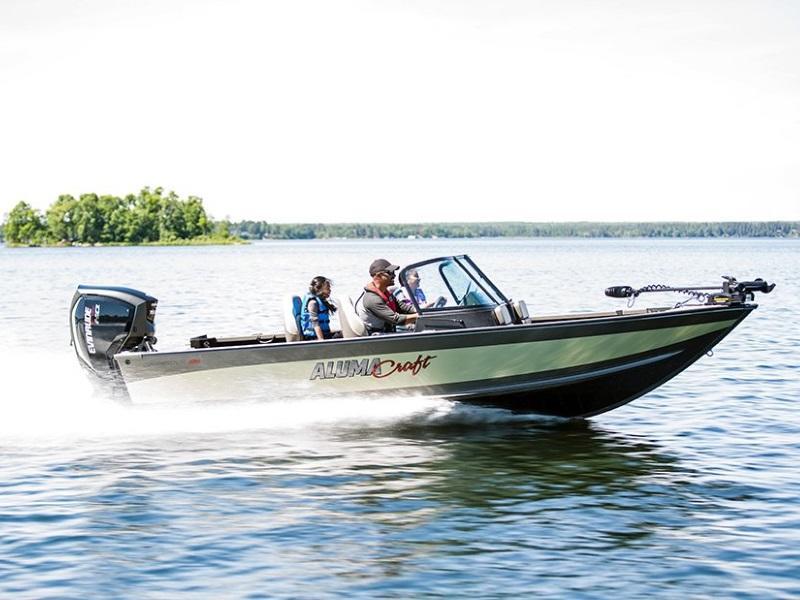 Family of three on a white 2021 Alumacraft Competitor fishing boat cruising through a body of water.